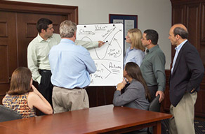 Businesspeople having a discussion around a whiteboard