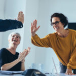 Business people giving each other high five and clapping. Business team celebrating success.